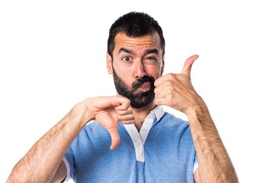 Adam mavi gömlek iyi-kötü işaret yapma ile