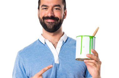 Mavi gömlekli bir boya pot tutan adamla