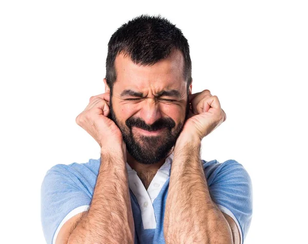 Hombre con camisa azul cubriéndose las orejas — Foto de Stock