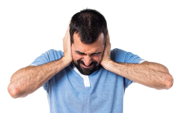 Man met blauwe shirt die betrekking hebben op zijn oren — Stockfoto