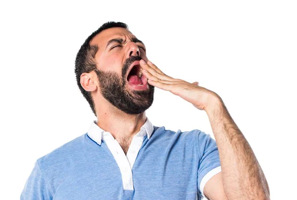 Человек в синей рубашке зевает — стоковое фото