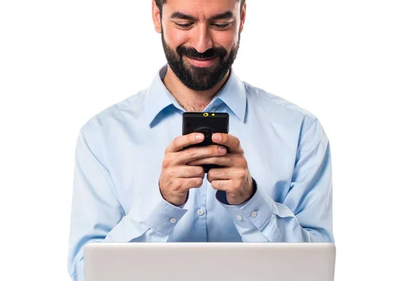 Man with laptop talking to mobile — Stock Photo, Image