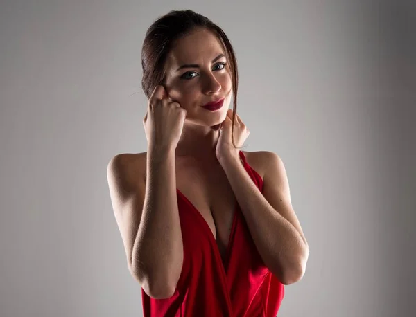Beautiful model woman posing in studio with a sexy red dress — Stock Photo, Image