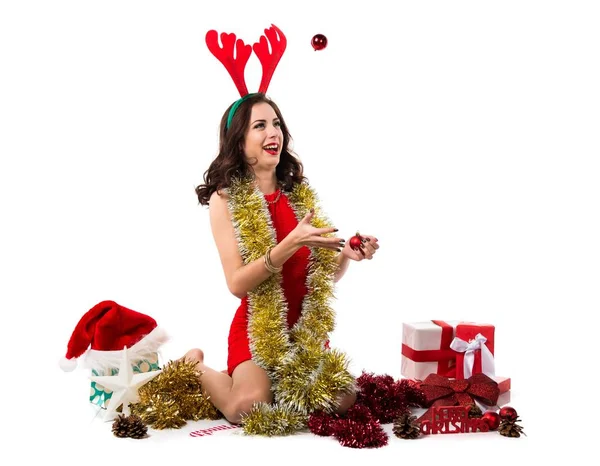 Hübsche junge Frau mit Weihnachtskugeln und Rentiergeweih — Stockfoto