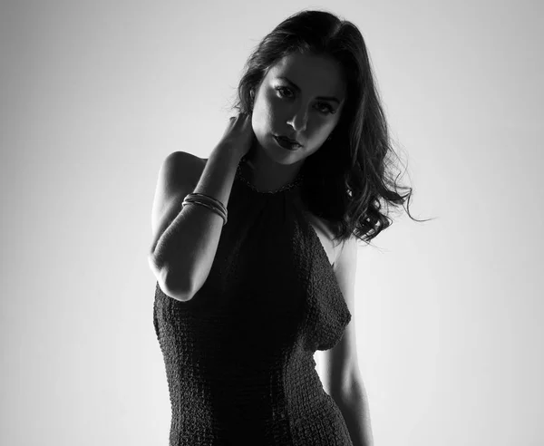 Брюнетка модель женщина позирует в студии в черно-белом — стоковое фото