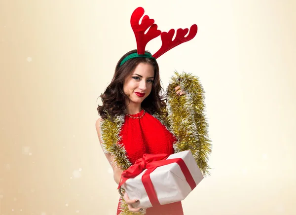 Bella giovane donna con regalo di Natale e corna di renna — Foto Stock