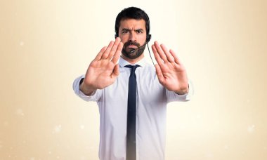 Dur işareti yapmak bir kulaklık ile genç adam