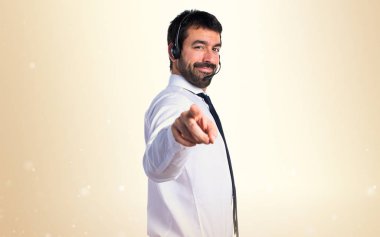 Öne doğru işaret eden bir kulaklık ile genç adam