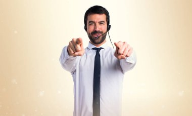 Öne doğru işaret eden bir kulaklık ile genç adam