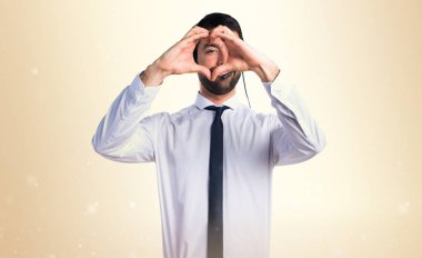 Elleri ile bir kalp yapma bir kulaklık ile genç adam