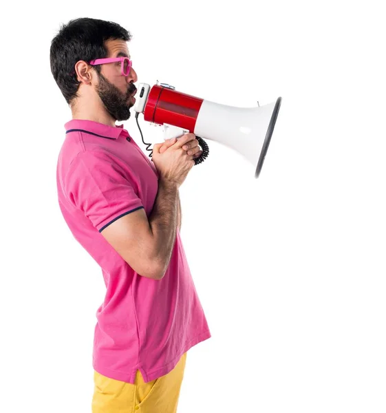 Mens in kleurrijke kleren schreeuwen door megafoon — Stockfoto