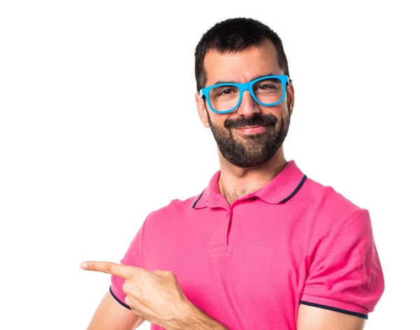 Man with colorful clothes pointing to the lateral — Stock Photo, Image