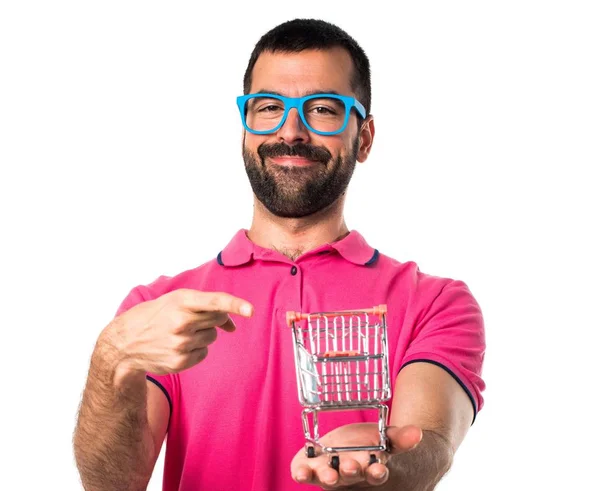 Άνθρωπος με πολύχρωμα ρούχα κρατώντας ένα παιχνίδι καλάθι σούπερ μάρκετ — Φωτογραφία Αρχείου