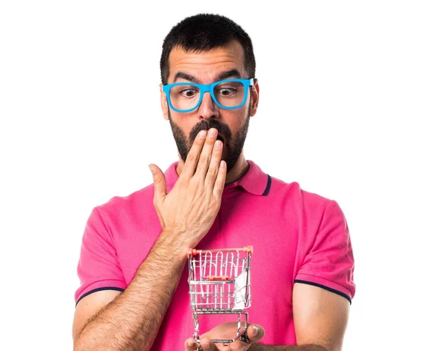 Άνθρωπος με πολύχρωμα ρούχα κρατώντας ένα παιχνίδι καλάθι σούπερ μάρκετ — Φωτογραφία Αρχείου