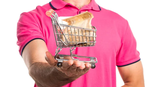 Hombre con ropa colorida sosteniendo un juguete de carro de supermercado con un — Foto de Stock