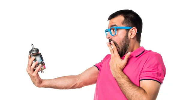 Человек в разноцветной одежде держит винтажные часы — стоковое фото