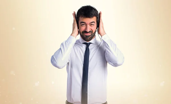 Young man with a headset covering his ears — Stock Photo, Image