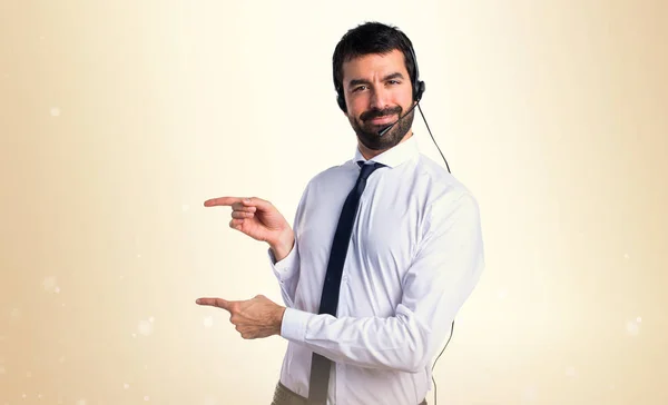 Jonge man met een headset die wijst naar de laterale — Stockfoto