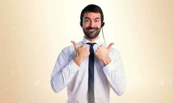 Jonge man met een headset met duim omhoog — Stockfoto