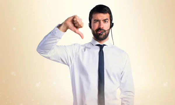 Joven con un auricular haciendo mala señal —  Fotos de Stock