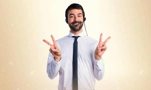 Jonge man met een headset doen overwinning gebaar — Stockfoto