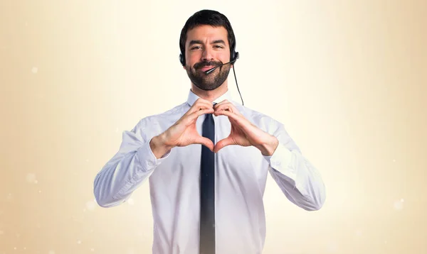 A fiatalember a fülhallgatóval, így a szív, a kezével — Stock Fotó
