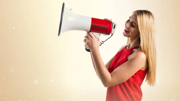 Blonde girl shouting by megaphone — Stock Photo, Image