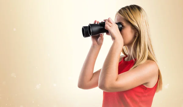 Blond meisje met een verrekijker — Stockfoto