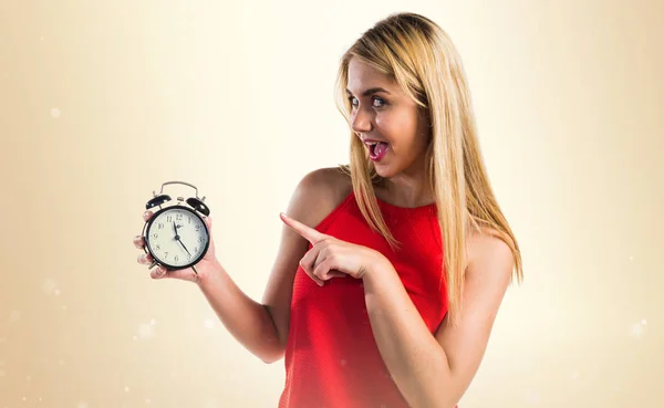 Menina loira segurando relógio vintage — Fotografia de Stock