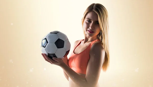 Jolie fille blonde tenant un ballon de football — Photo
