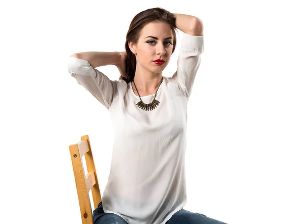 Young pretty model woman posing in studio on chair — Stock Photo, Image