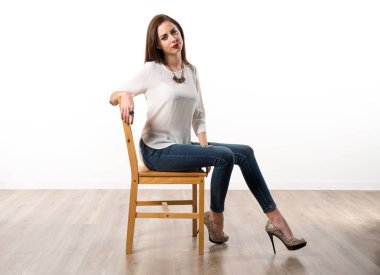 Genç güzel model kadın sandalyede Studio'da poz