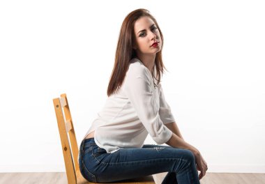 Genç güzel model kadın sandalyede Studio'da poz