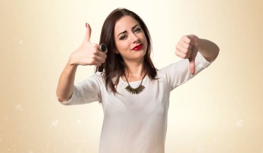 Genç ve güzel kız iyi-kötü işaret yapma