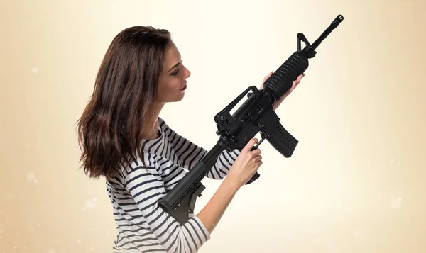 Ganska ung flicka håller en pistol — Stockfoto