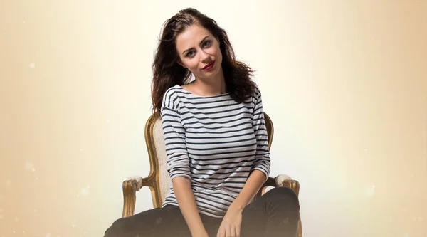 Bella modella donna in posa in studio con una poltrona vintage — Foto Stock
