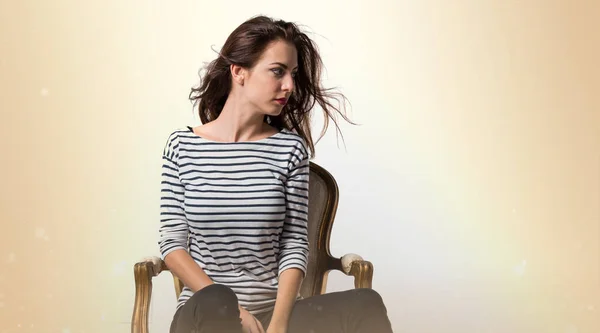 Красивая модель женщина позирует в студии с винтажным креслом — стоковое фото