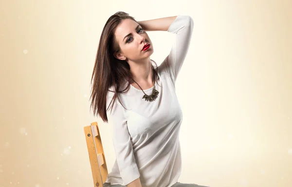Joven modelo bonita mujer posando en estudio en silla —  Fotos de Stock
