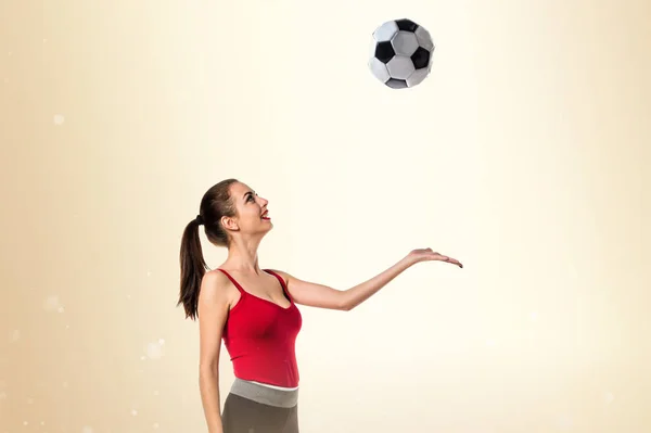 Jolie femme sportive tenant un ballon de football — Photo