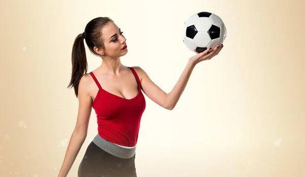 Pretty sport woman holding a soccer ball — Stock Photo, Image