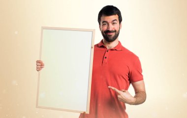 Yakışıklı adam boş bir afişini holding