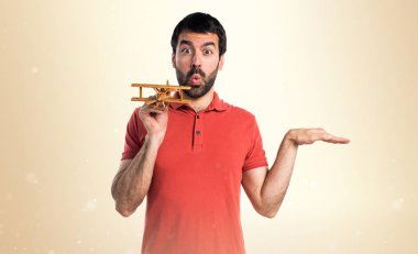 Yakışıklı adam ahşap oyuncak uçak holding