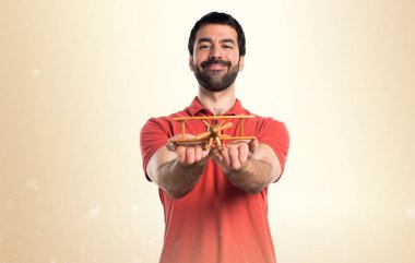 Yakışıklı adam ahşap oyuncak uçak holding