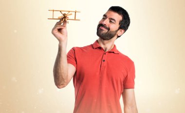 Yakışıklı adam ahşap oyuncak uçak holding