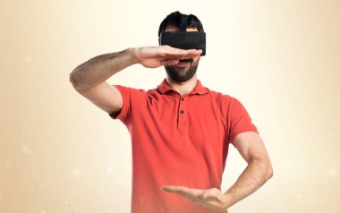 VR glassesa kullanarak ve bir şey tutan yakışıklı adam