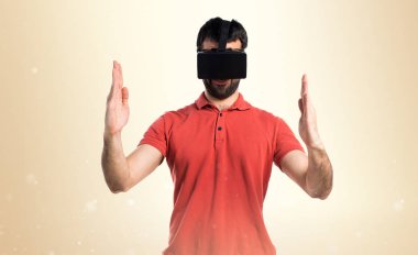 VR glassesa kullanarak ve bir şey tutan yakışıklı adam