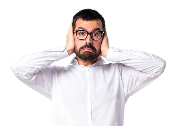 Hombre guapo con gafas cubriéndose las orejas —  Fotos de Stock