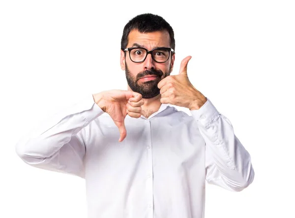 Knappe man met bril goed-slecht teken te maken — Stockfoto