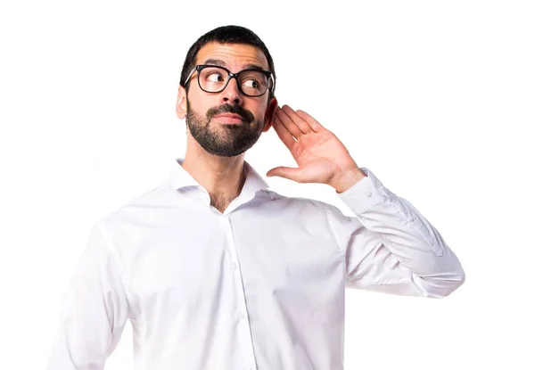 Bel homme avec des lunettes écoutant quelque chose — Photo