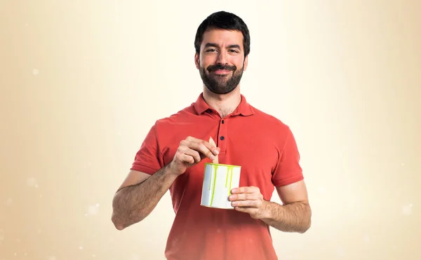 Bonito homem segurando um pote de tinta — Fotografia de Stock